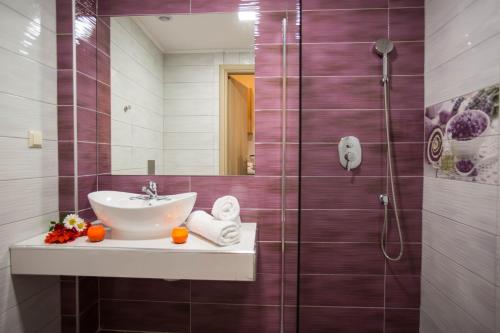 a bathroom with a sink and a shower at Kozanos Hotel & Suites in Amoudi
