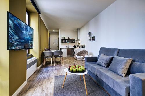 a living room with a couch and a table with fruit at Apartamentos AL-QAZERES LUXURY La Concepción in Cáceres