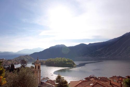 a view of a lake with a clock tower and a building at Residence Sala Comacina apartment no 2 with pool and spa by Italian Apartments in Isola Comacina