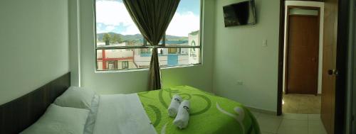 a bedroom with a bed with two stuffed animals on it at Hotel Riviera Confort in Pasto