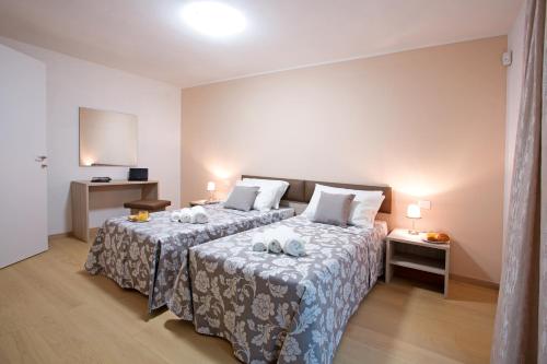 a bedroom with two beds in a room at Residence Sala Comacina apartment no 2 with pool and spa by Italian Apartments in Isola Comacina