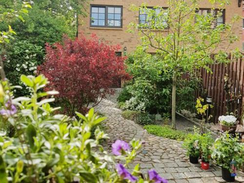un jardín con un camino de piedra frente a una casa en Ferienwohnung am Stadthafen _ Obje en Rostock