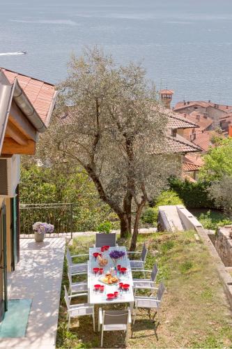 a table and chairs with a table and a tree at Residence Sala Comacina apartment no 2 with pool and spa by Italian Apartments in Isola Comacina