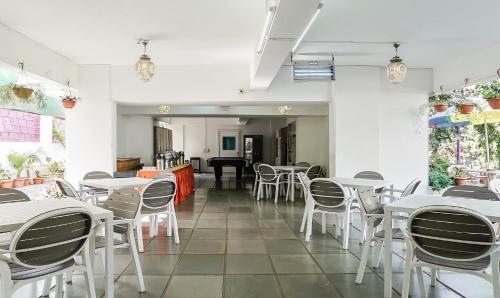 a dining room with white tables and chairs at Treebo Brooks Manor in Pune