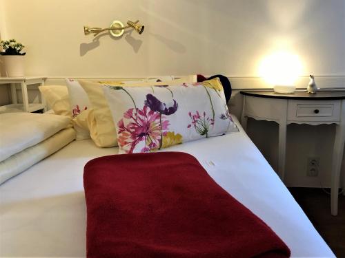 Apartment Happy Mosel في كوشيم: غرفة نوم بسرير أبيض مع بطانية حمراء