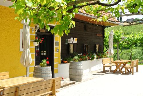 a patio with tables and umbrellas in front of a building at Weingut Primus Südsteiermark in Spielfeld