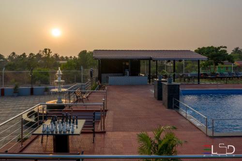 a patio with a pool and tables and a fountain at Salcete Beach Resort in Colva