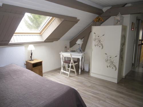 een slaapkamer met een bed, een bureau en een raam bij Gîte de campagne Dromard in Sancey-le-Long