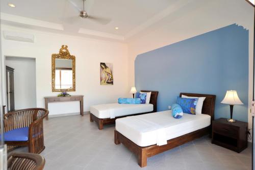 a hotel room with two beds and a mirror at Aquarius Beach Hotel in Sanur