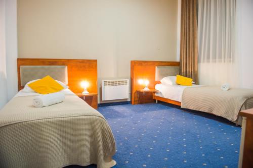 a hotel room with two beds with yellow pillows at Hotel CITY in Prnjavor