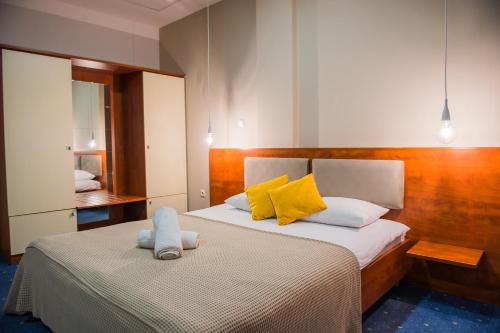 sypialnia z 2 łóżkami z żółtymi i białymi poduszkami w obiekcie Hotel CITY w mieście Prnjavor