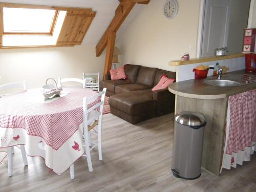 kuchnia i salon ze stołem i kanapą w obiekcie Gîte de campagne Dromard w mieście Sancey-le-Long