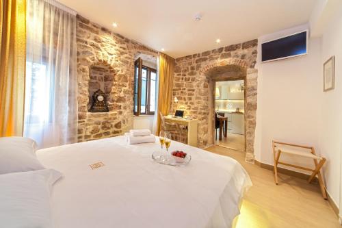 una camera da letto con un letto bianco e un muro di pietra di Golden Palace a Spalato (Split)