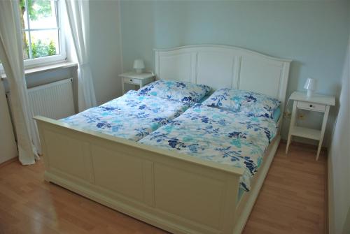 a bedroom with a bed with blue flowers on it at Villa Schaller - Apartment in Krumpendorf am Wörthersee