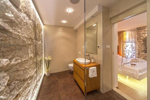 ein Badezimmer mit einem Waschbecken, einem WC und einem Spiegel in der Unterkunft Golden Palace in Split