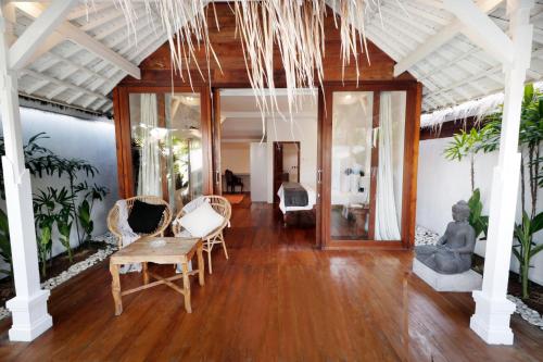 a living room with wooden floors and chairs and a table at The Apartments Canggu in Canggu