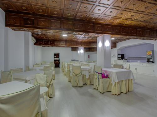a banquet hall with white tables and white chairs at Emperatriz I in Salamanca