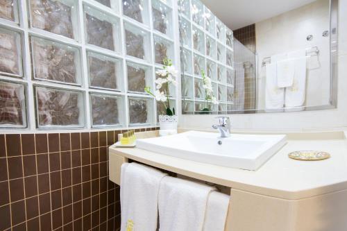 a bathroom with a sink and a mirror at Apartamentos El Tajo & SPA in Ronda