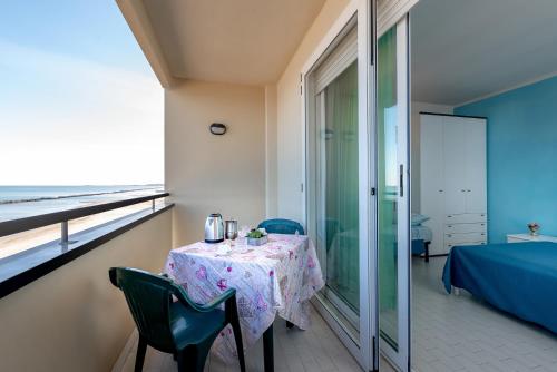 um quarto com uma mesa e vista para o oceano em Residence Belvedere Vista em Rimini