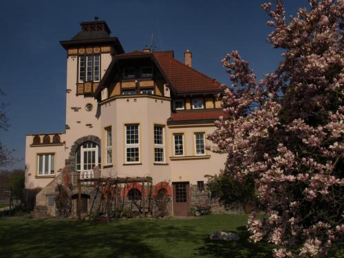 une grande maison avec une tour au-dessus d'une cour dans l'établissement Amálie Vila 1921 secesní nostalgie, à Olomouc