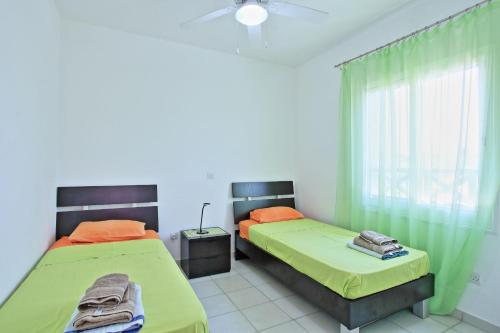 two beds in a room with green and orange at Villa Irina Polis in Polis Chrysochous