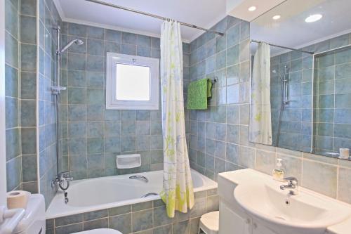 a bathroom with a tub and a sink and a toilet at Villa Irina Polis in Polis Chrysochous