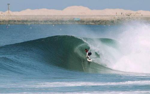 une personne à bord d'une vague sur une planche de surf dans l'océan dans l'établissement Wherry Green Guest House (PRAIA DA BARRA)❤️, à Praia da Barra