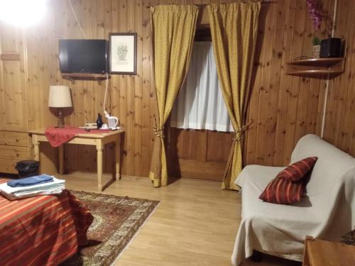 a living room with a couch and a table and a television at Baita Layet in Breuil-Cervinia