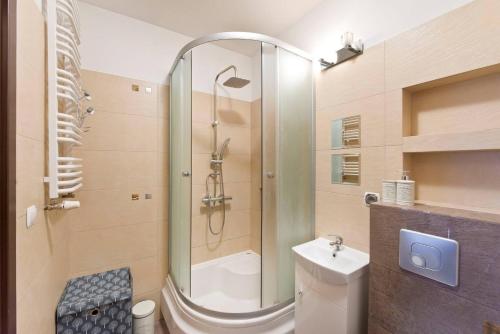 uma casa de banho com um chuveiro, um WC e um lavatório. em Apartament Zaciszny em Gdansk