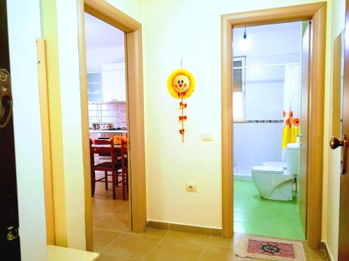 a bathroom with a door open to a bathroom with a toilet at Turtle Apartment in Durrës
