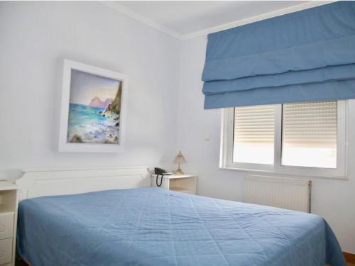 a bedroom with a blue bed and a window at Elaia Sitia Center Sea View Apartment in Sitia