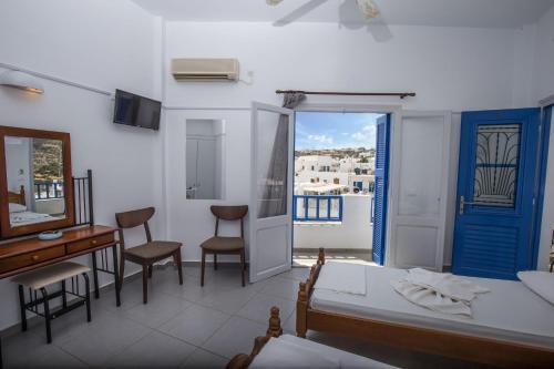 Schlafzimmer mit einem Schreibtisch, einem Tisch und Stühlen in der Unterkunft Hotel Sofia in Apollonia