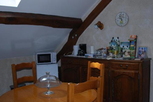 Il comprend une cuisine avec une table en bois et un comptoir. dans l'établissement La Petite Marguerite, à Chitenay