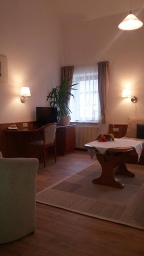 - un salon avec une table au milieu d'une pièce dans l'établissement Altes Wirtshaus Fördergersdorf Bed & Breakfast, à Tharandt
