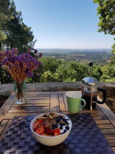 a table with a bowl of fruit and a cup of coffee at Quinta da Barroquinha in Vale de Prazeres