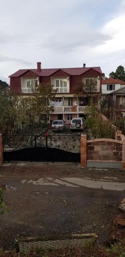 una casa con coches aparcados en un estacionamiento en Gios Guest House, en Chakvi