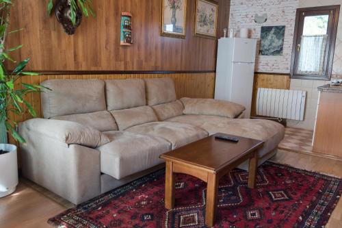 - un salon avec un canapé et une table dans l'établissement Apartamentos Jardines de Llanes, à Pancar