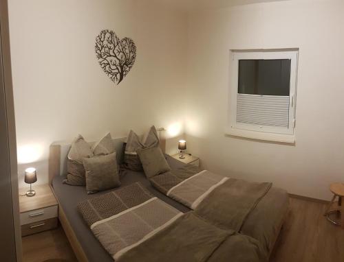 1 dormitorio con 1 cama y un corazón en la pared en Ferienwohnung FERRUM, en Korbach