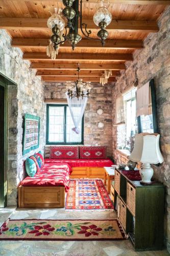 a bedroom with a red bed in a stone wall at Liodentro - Olea in Plataria