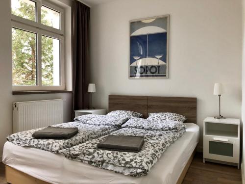 1 dormitorio con 1 cama grande y 2 almohadas en VIU Garden & Sun, en Sopot
