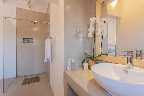 a bathroom with a white sink and a mirror at Seeplaas Guesthouse in Groot Brak Rivier