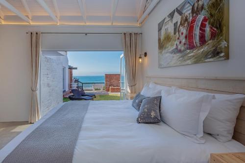 a bedroom with a bed with a view of the ocean at Seeplaas Guesthouse in Groot Brak Rivier
