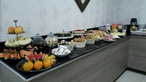 uma linha de buffet com muitos tipos diferentes de alimentos em Star Hotel em Chapecó
