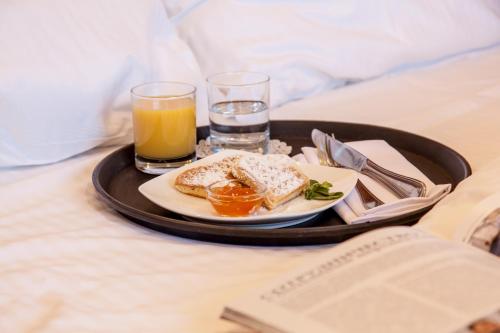 a tray with a plate of food and drinks on a bed at Eurootel Stavropol in Stavropol
