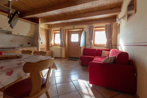 een woonkamer met een rode bank en een tafel bij Toilain in Livigno