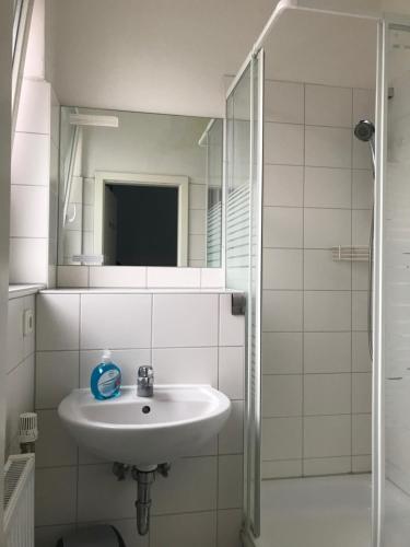 a bathroom with a sink and a shower with a mirror at Hostel Inn-Berlin in Berlin
