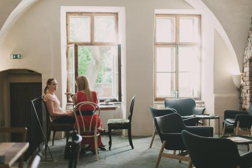 two women sitting at a table in a room at Miss Sophie's Olomouc - Boutique Hotel in Olomouc