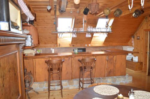 eine Küche mit einer Bar und Hockern in einer Hütte in der Unterkunft Penzion 409 in Horní Branná