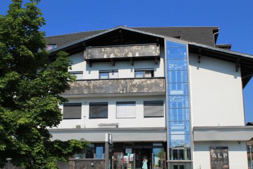a white building with a sign on it at Alp Art Hotel Götzens in Innsbruck