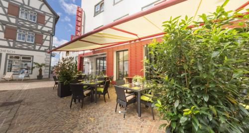 eine Terrasse mit Tischen und Stühlen außerhalb eines Gebäudes in der Unterkunft Hotel Ochsen in Bad Saulgau